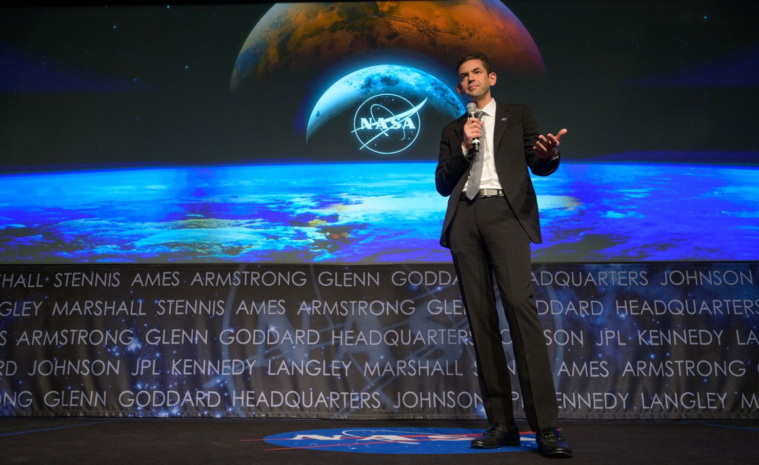 En man står på en scen och håller en mikrofon