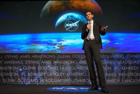 Jared Isaacman.jpg En man står på en scen och håller en mikrofon