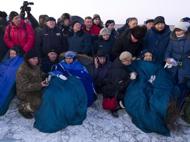 Tre besättningsmän från ISS. Mike Fossum till vänster och flygmaskinisten Sergei Volkov i mitten och Satoshi Furukawa till höger bara några minuter efter att de landadat i ett avlägset område utanför staden Arkalyk i Kazakstan.