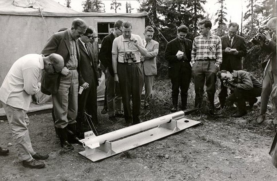 Bilden är tagen vid pressvisningen vid startplatsen den 9 augusti 1961. Mannen med kikaren var försökledaren Tord Lundblad. Mannen i den rutiga skjortan är professor Bert Bolin, Meteorologiska Institutionen, Stockholms Universitet.