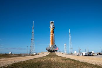 KSC-01172026-Artemis II_Rollout-24~large.jpg En raket på marken mot en blå himmel