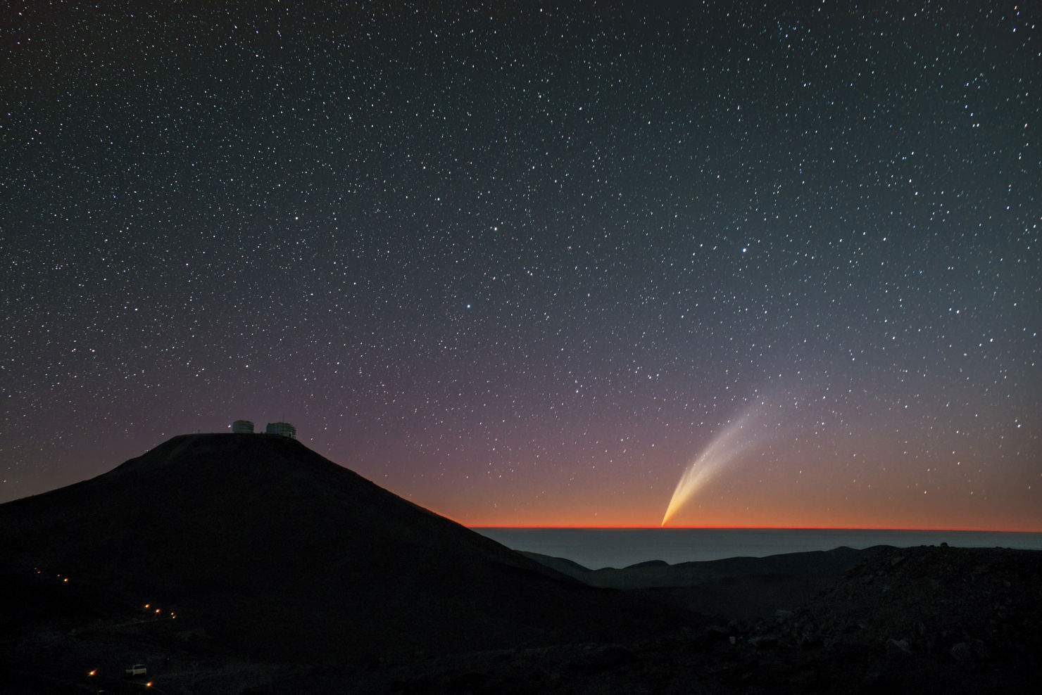 En stjärnhimmel och en komet över ett observatorium