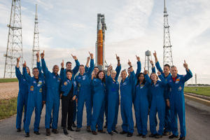 Jessica Artemis raket.jpg Astronauter i blå dräkter som pekar upp mot himlen