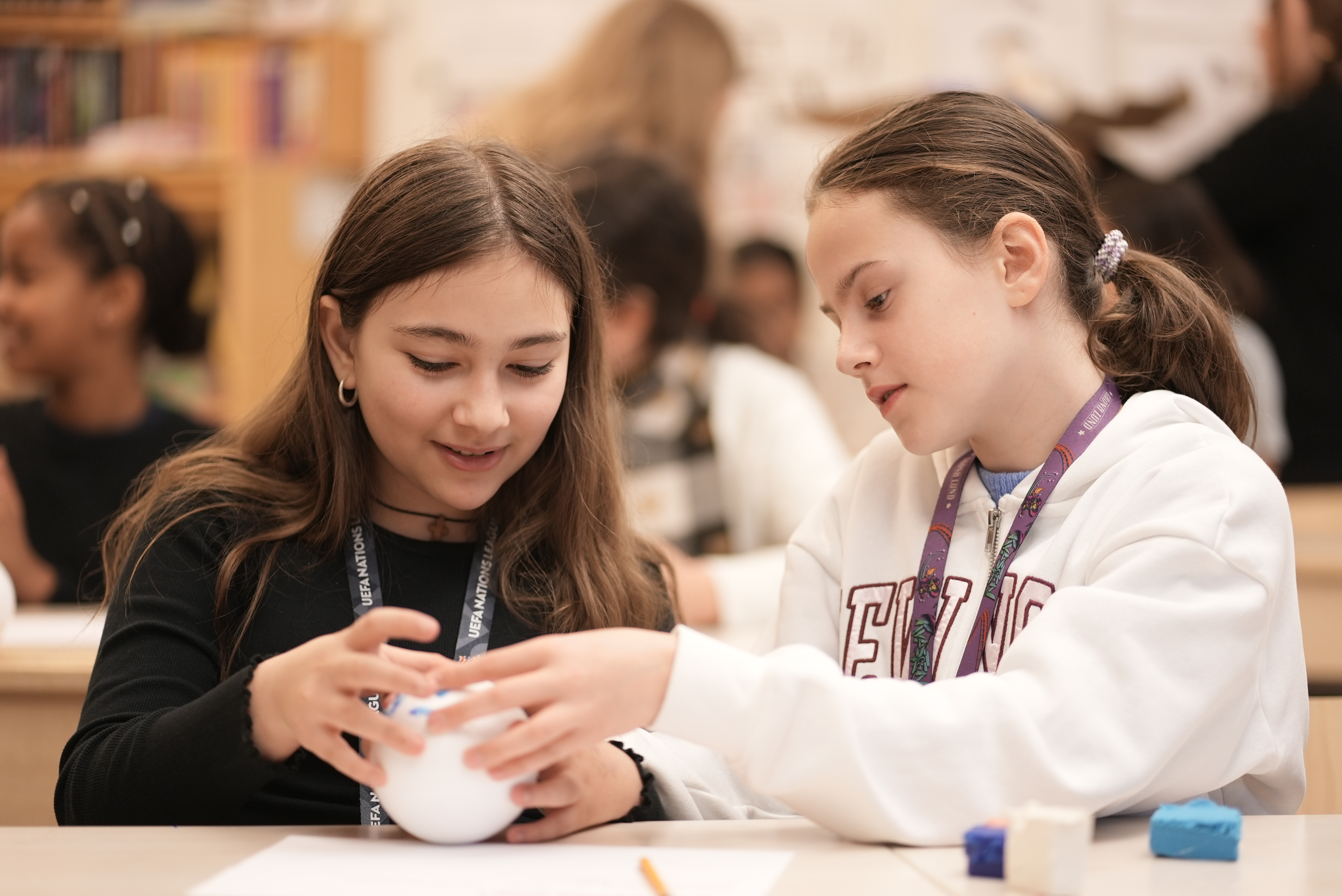 Två flickor som sitter och pysslar