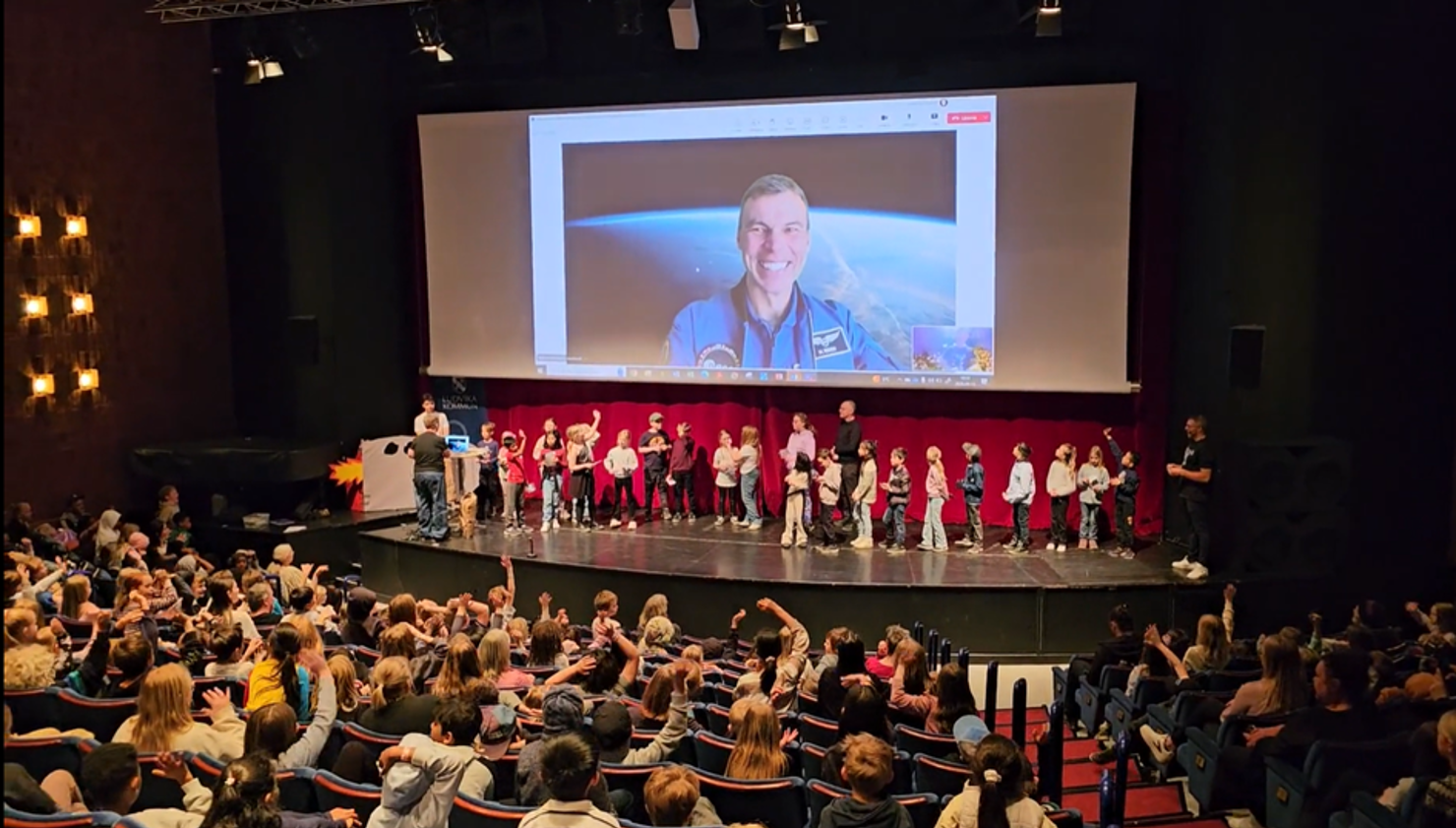 Barn på en scen framför en publik.