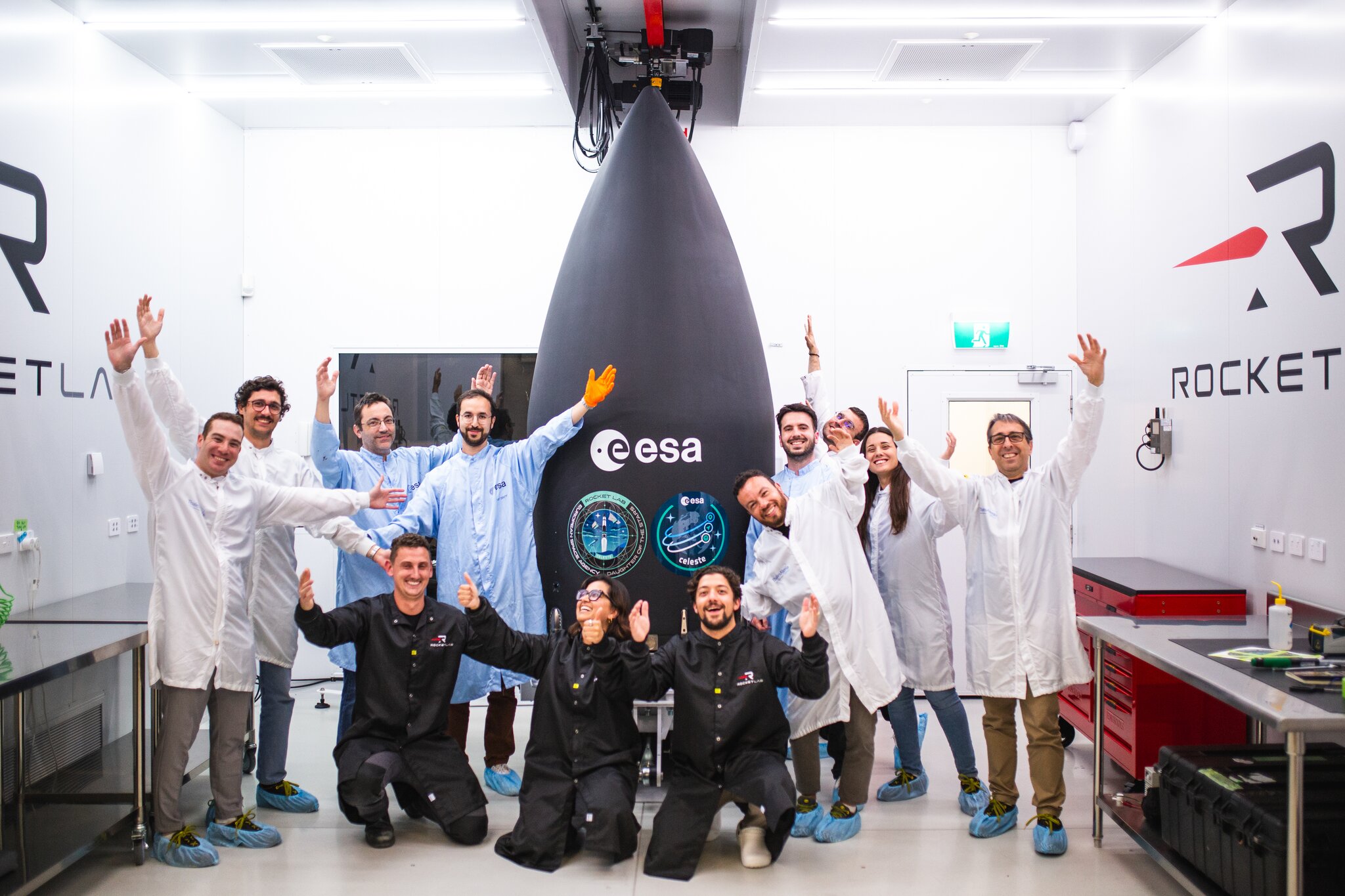 Människor som står och ser glada ut framför en raket