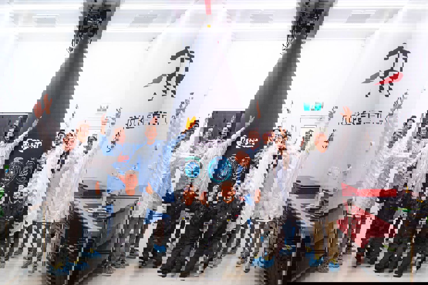 Människor som står och ser glada ut framför en raket