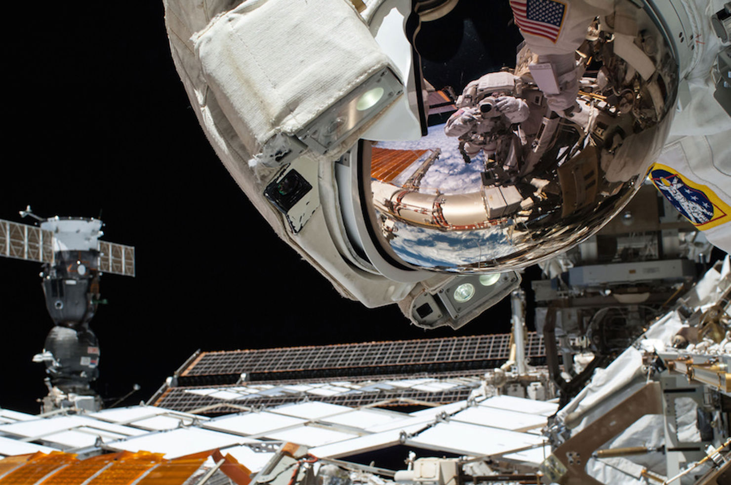 I astronauten Reid Wisemans visir speglas bilden av kollegan Barry Wilmore under en rymdpromenad 2014.