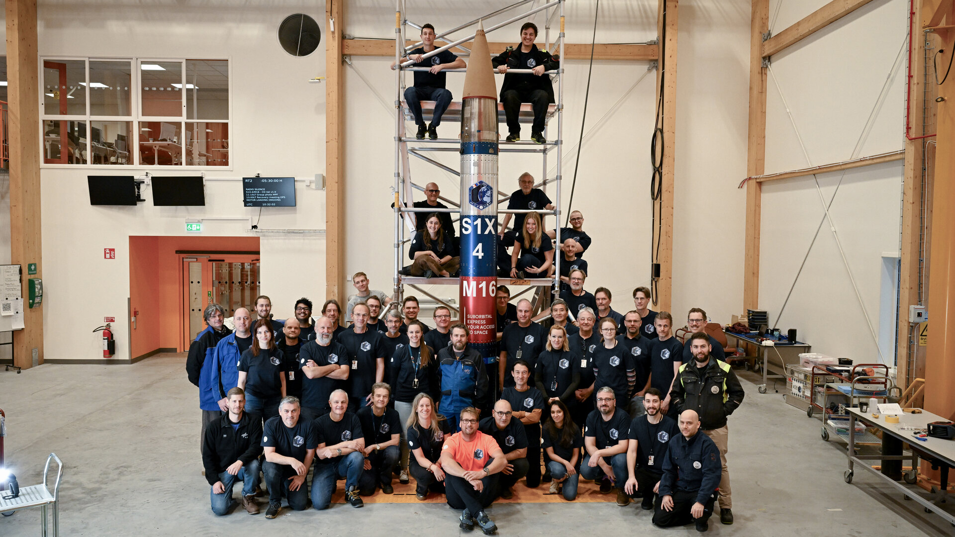 En grupp människor med raketen i hangaren