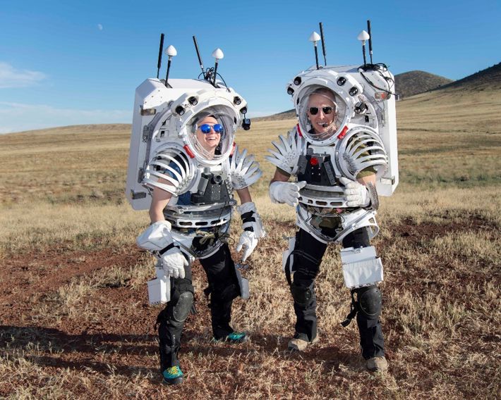 Astronauter med konstiga dräkter i öknen