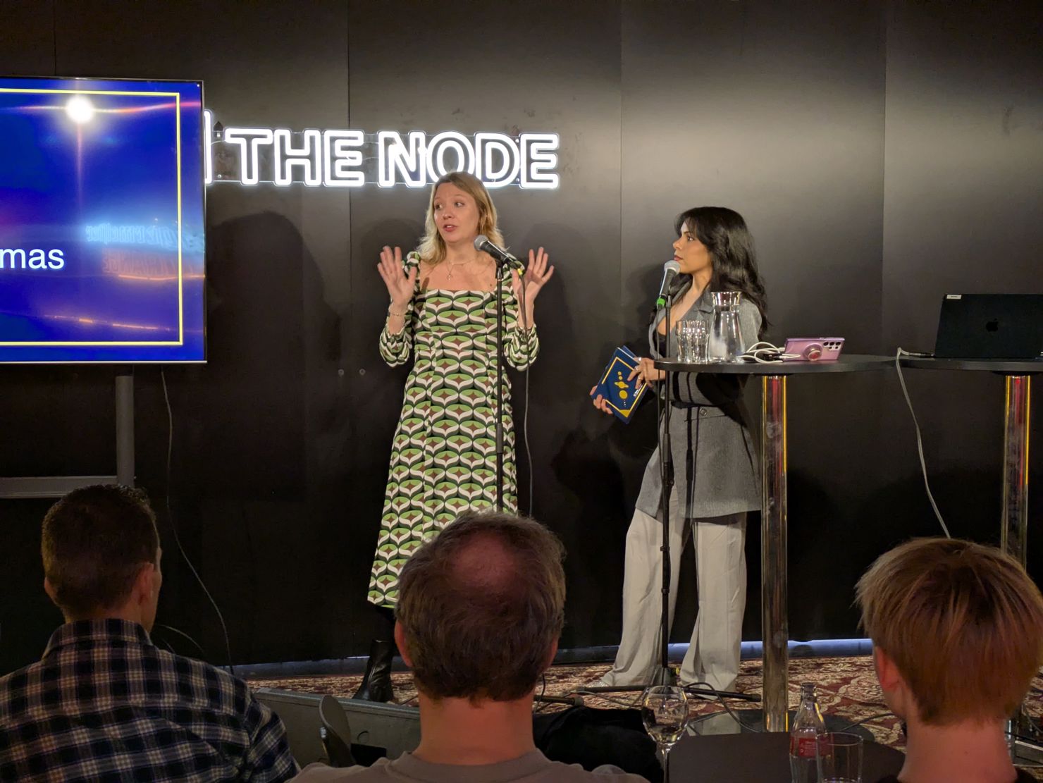 Två kvinnor står på en scen.