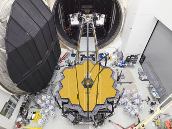 James Webb-teamet poserar bredvid det stora rymdteleskopet utanför testkammaren.