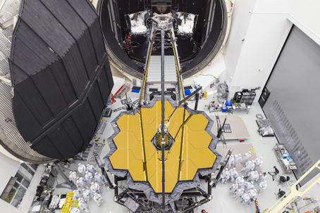 James Webb-teamet poserar bredvid det stora rymdteleskopet utanför testkammaren.