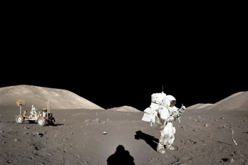 Apollo 17-astronauten Jack Schmitt står på månens yta. I bakgrunden syns den rover astronauterna hade med sig.