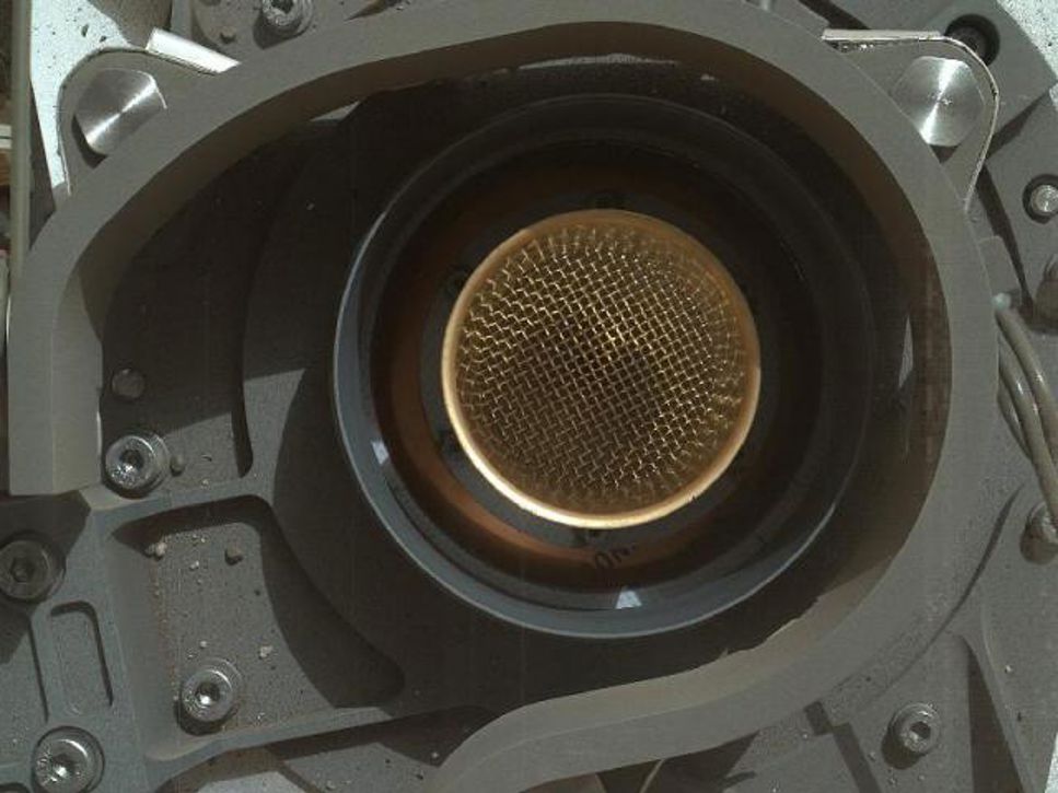 curiosity_2_0.jpg Denna bild från NASA: s Curiosity rover visar locket på ett inlopp där pulveriserade sten och jordprover ska tas in för analys.
