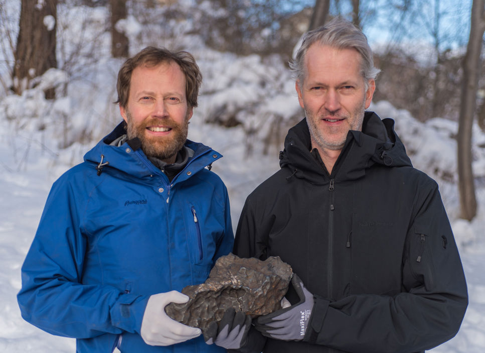 Två män håller i en meteorit.