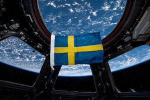 Svensk flagga rymden.jpg En svensk flagga som svävar med jorden som bakgrund