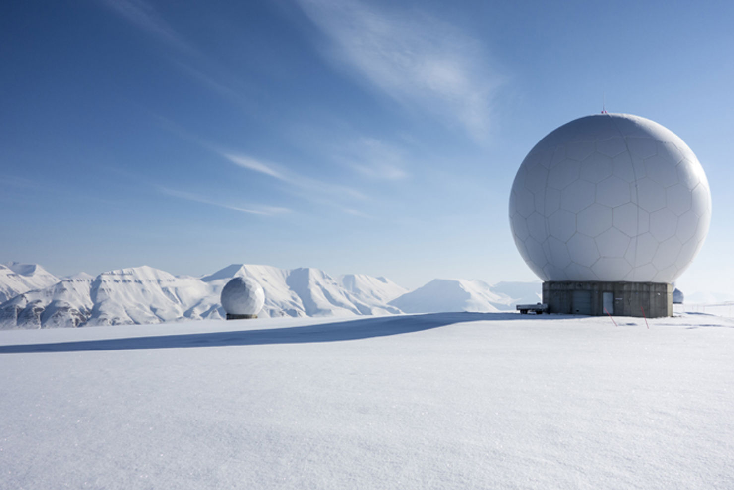 På Svalbards snötäckta kullar finns flera paraboler riktade mot rymden som liknar gigantiska golfbollar. 