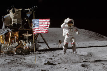 Astronaut John W. Young, befälhavare för Apollo 16:s månlandningsuppdrag, hoppar från månytan när han hyllar USA:s flagga vid landningsplatsen Descartes under den första extravehikulära aktiviteten på Apollo 16.