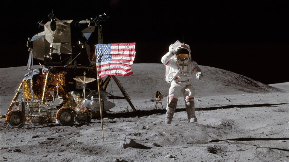 Astronaut John W. Young, befälhavare för Apollo 16:s månlandningsuppdrag, hoppar från månytan när han hyllar USA:s flagga vid landningsplatsen Descartes under den första extravehikulära aktiviteten på Apollo 16.