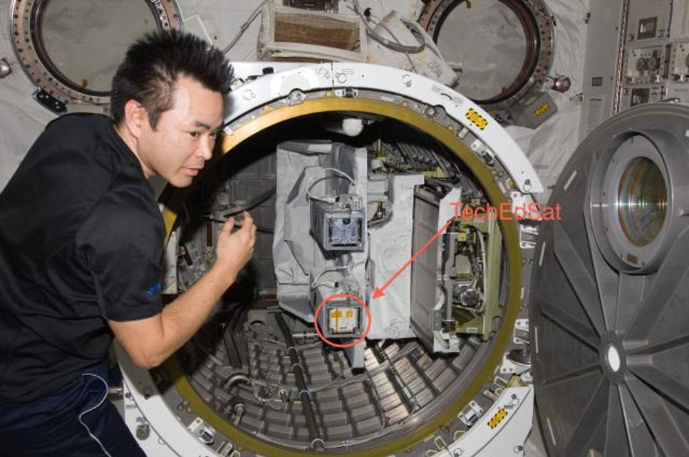 Astronauten Hoshide kontrollerar satelliterna innan det är dags att skjuta ut dem i rymden.