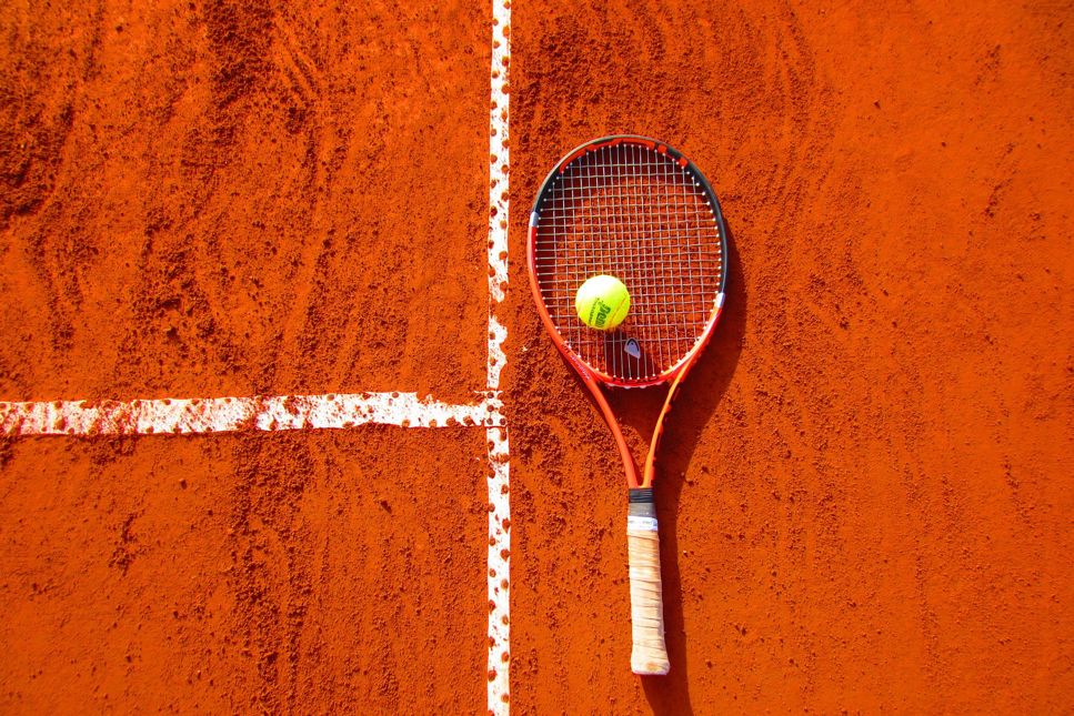 Tennisracket med boll på bana.