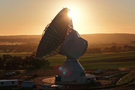 ESA_s_fourth_deep_space_antenna_in_New_Norcia_Australia_pillars.jpg En stor antenn i motljus