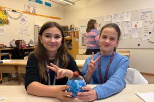 IMG_0141.jpg Två flickor gör två fingrar upp med en pysslad planet i handen