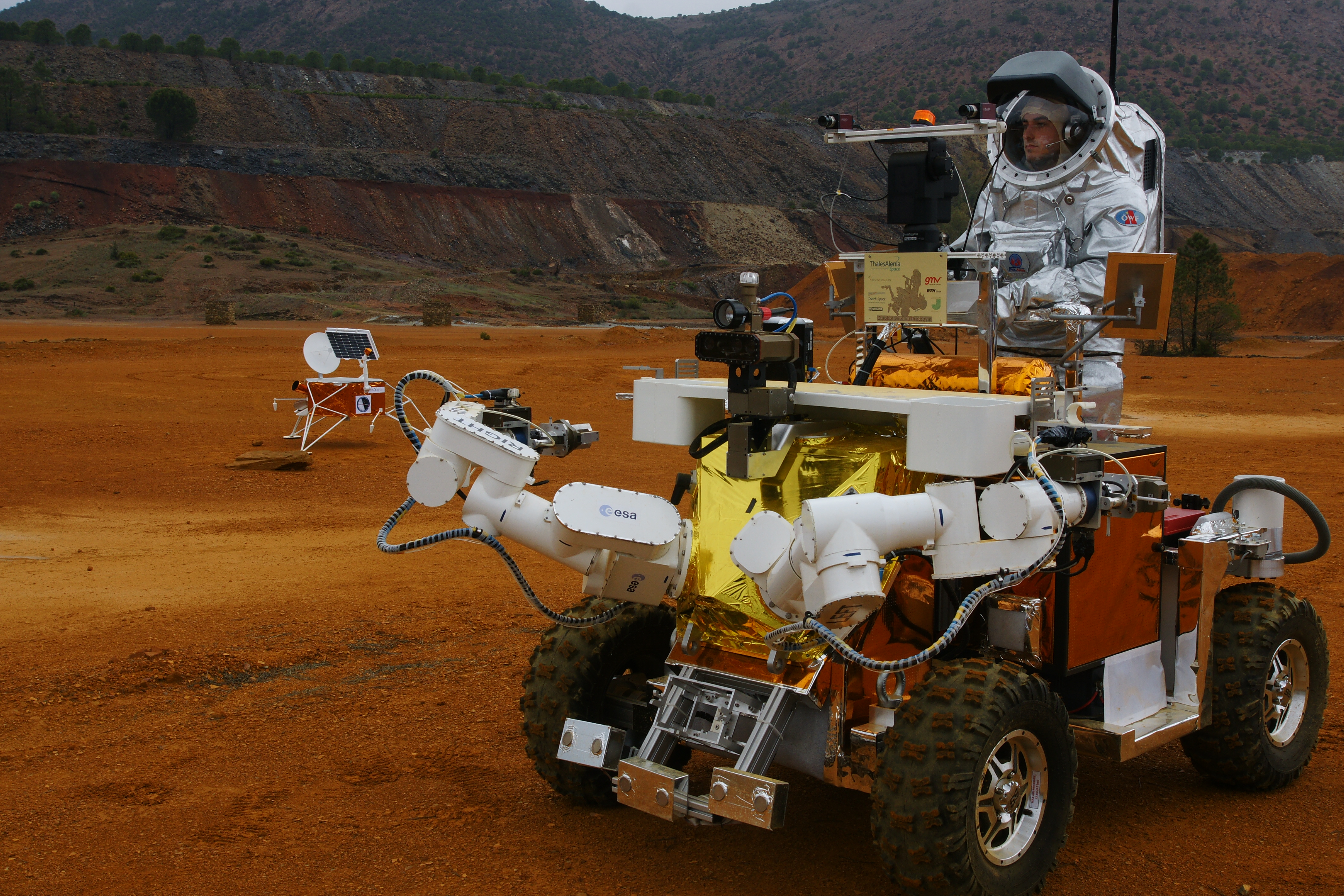 En astronaut som kör på en sorts liten bil med rymddräkt på sig.