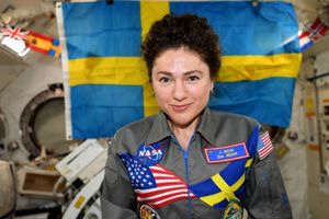 Jessica Meir ombord på den internationella rymdstationen ISS. På sin overall har hon Svenska flaggan och USA:s flagga. I bakgrunden syns en stor svensk flagga.