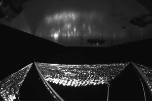 Första bilden från solar sail system En svartvit bild tagen från Solar Sail System på plats i rymden. Det är svårt att avgöra vad bilden visar.I bildens nederkant ser vi ett silvrigt reflekterande material som ser ut som folie, kontrasterat mot en svart bakgrund. Det är farkostens reflekterande segel. I bildens överkant ser vi baksidan av en av farkostens solpaneler.