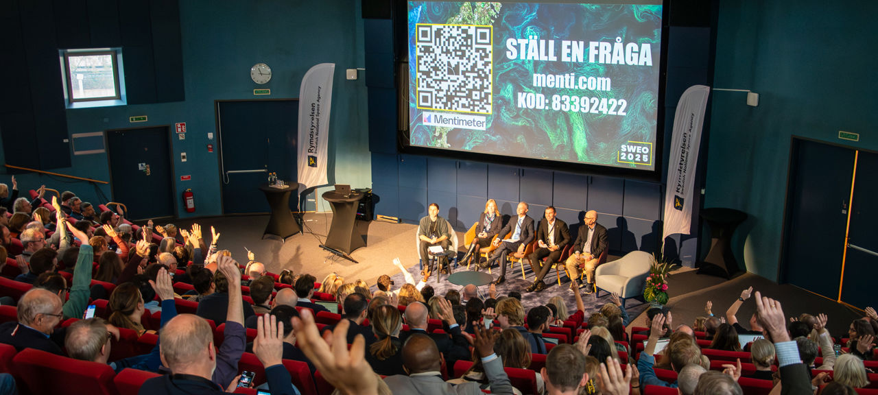 DSC_0047.jpg En publik räcker upp händerna till en intresserad panel.