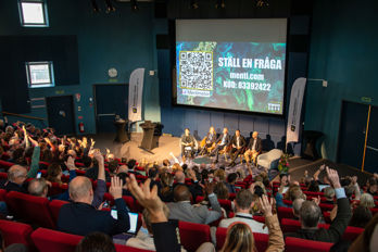 DSC_0047.jpg En publik räcker upp händerna till en intresserad panel.