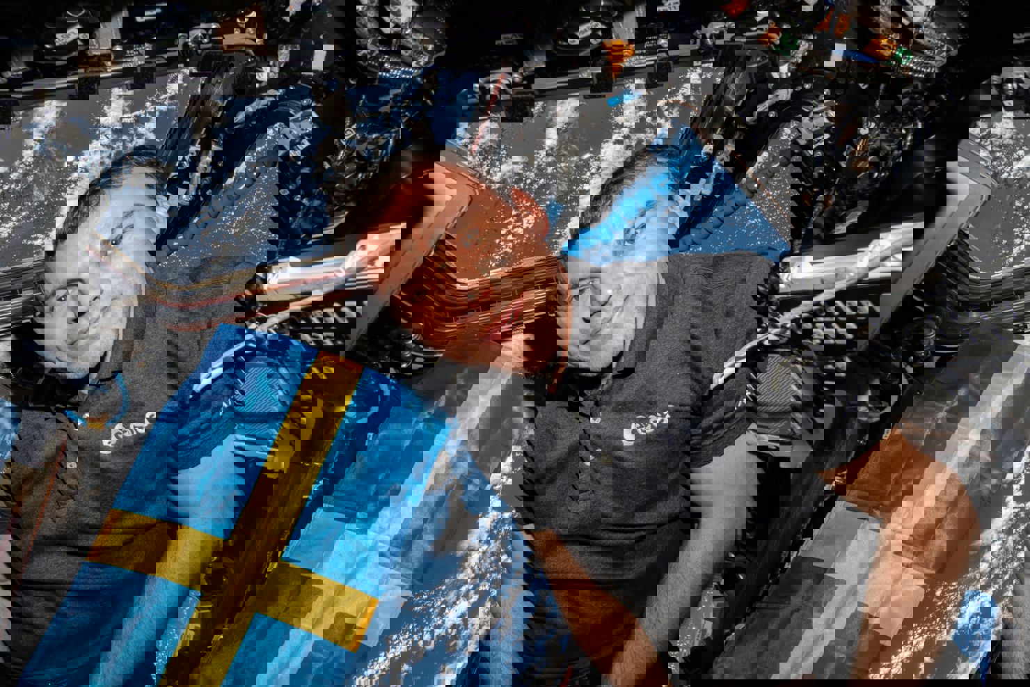 Marcus Wandt med svensk flagga i Cupolan på den internationella rymdstationen