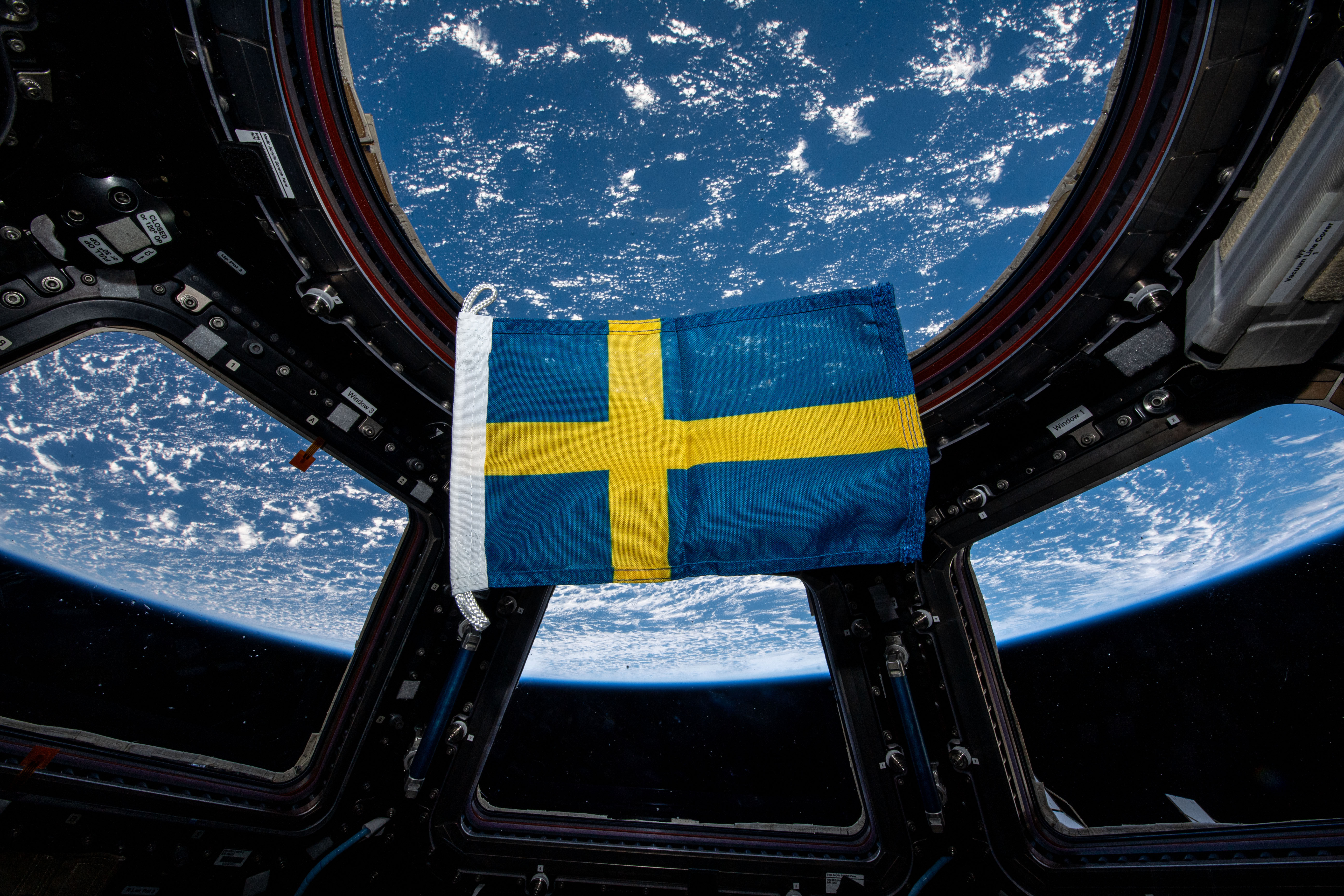En svensk flagga som svävar i tyngdlöshet på den internationella rymdstationen.